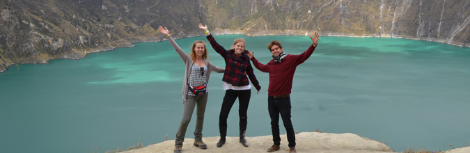 3 Volunteers posing for a photo with Quilotoa Lake in Ecuador