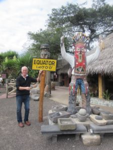 Man posing beside festival statue in Ecuador